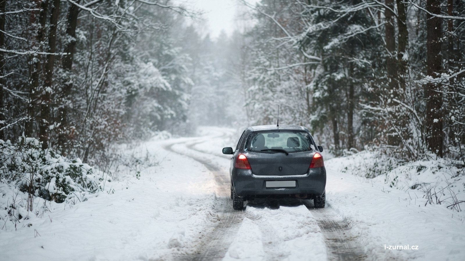 Auto na zasněžené silnici mezi stromy