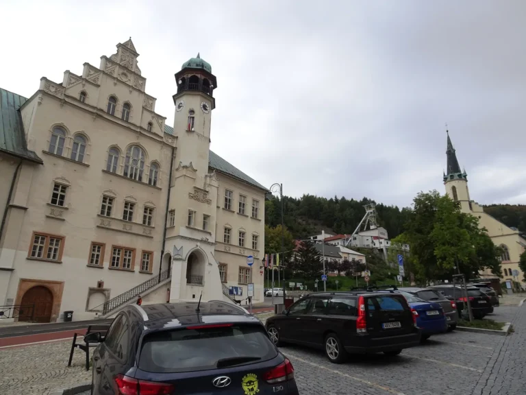 Jáchymovská radnice, důlní areál a kostel na fotografii z roku 2023. Ilustrace prostředí první řady Rapla; nejde o záběr ze seriálu.