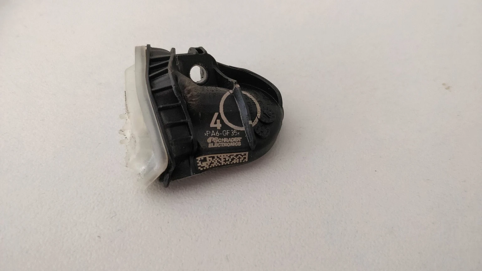 Poškozený snímač TPMS z vozu Opel Astra K; ukázka součásti přímého systému, nikoli diagnóza každé rozsvícené kontrolky.